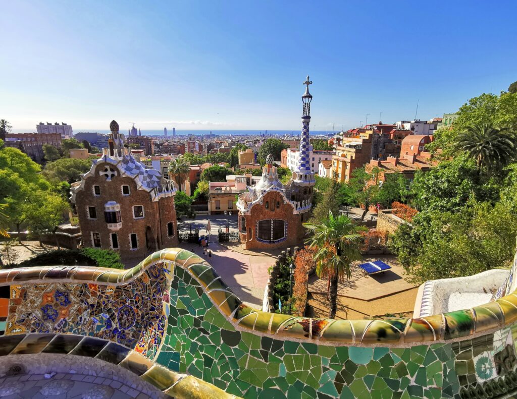 A view of Park Güell in Barcelona, with tile work by Gaudi on a wall in the foreground.